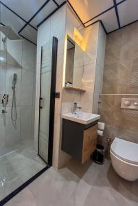 a bathroom with a sink and a shower and a toilet at Rain Hotel in Kizkalesi