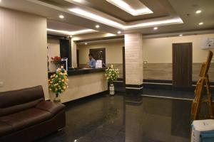 a lobby with a man standing at a counter at Hotel Vip Square in Puri