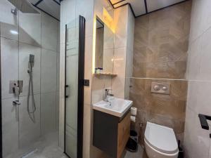 a bathroom with a toilet and a sink and a shower at Rain Hotel in Kizkalesi