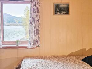 una camera da letto con finestra affacciata sull'acqua di Holiday home Bygstad a Bygstad