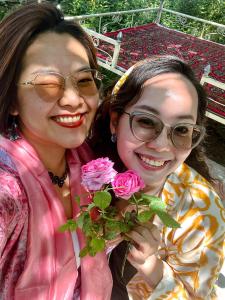 Twee vrouwen lachen en houden roze rozen vast. bij "Sofia" Guest House in Samarkand