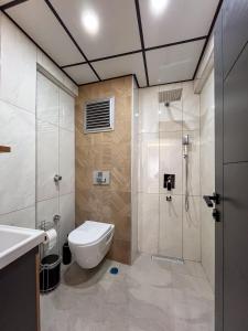 a bathroom with a toilet and a shower and a sink at Rain Hotel in Kizkalesi