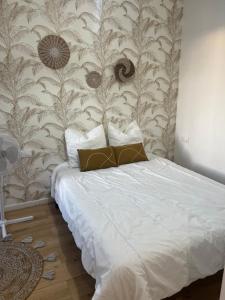um quarto com uma cama branca e uma parede em Appartement confortable Olympic games JO24 em Aubervilliers