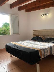 1 cama en un dormitorio con ventana en CASAPIANA 05, en San-Gavino-di-Carbini