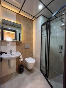 a bathroom with a toilet and a sink and a shower at Rain Hotel in Kizkalesi
