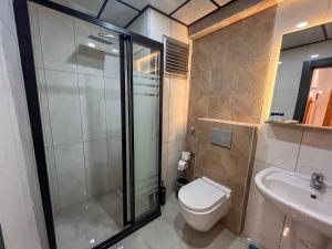 a bathroom with a shower and a toilet and a sink at Rain Hotel in Kizkalesi