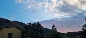un cielo nuvoloso sopra una casa con montagne sullo sfondo di CASA ORCHIDEA a Portoferraio