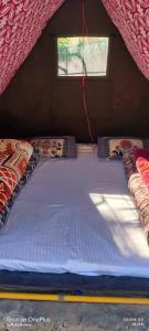 a large bed in a small room with a window at Wild trip cafe in Kasol