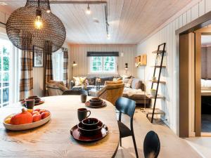 a dining room and living room with a table and chairs at 10 person holiday home in Fåvang in Strande