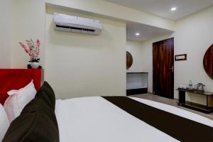 a bedroom with a bed with a air conditioner on the wall at OYO Hotel HILL PARK I in Vadodara
