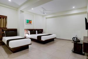 a hotel room with two beds and a television at OYO Hotel HILL PARK I in Vadodara