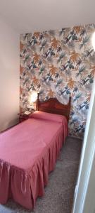 1 dormitorio con cama roja y pared en Hotel El Doncel, en Atarfe