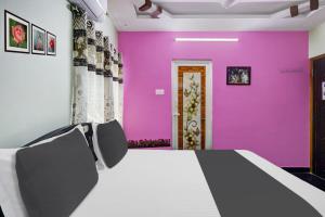 a room with a table and purple walls at OYO SS Home Stay - An Unique Home Stay in Tirupati
