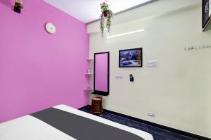 una camera con pareti rosa e bianche e un letto di OYO SS Home Stay - An Unique Home Stay a Tirupati