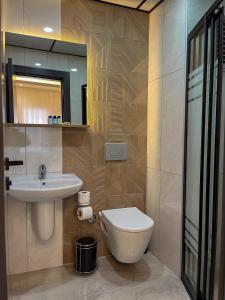a bathroom with a sink and a toilet and a mirror at Rain Hotel in Kizkalesi