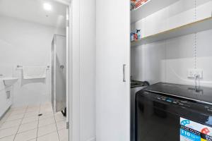 a kitchen with a black dishwasher and a bathroom at Lightview Oasis- Modern 2BR Apt- WiFi & Parking in Broadview