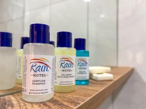 four bottles of hair products sitting on a wooden shelf at Rain Hotel in Kizkalesi