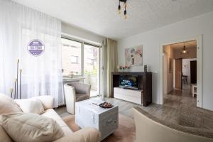 sala de estar con sofá blanco y TV en 2 Zi Wohnung inkl WLAN NETFLIX 3D Tour, en Mönchengladbach