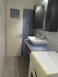 a bathroom with a sink and a toilet and a mirror at Kipseli house in Athens