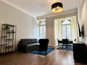 - un salon avec un canapé, une table et des chaises dans l'établissement Balcony Apartment, 4 min to U3 Zipperer Straße, à Vienne