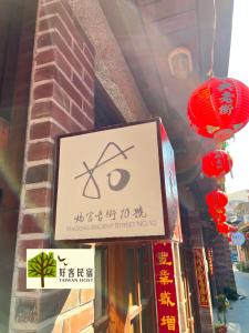 ein Schild auf einem Gebäude mit roten Laternen in der Unterkunft 媽宮古街10號 in Magong