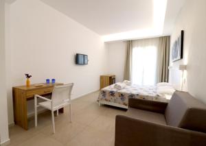Schlafzimmer mit einem Bett, einem Schreibtisch und einem Stuhl in der Unterkunft Borgo dei Pescatori in Capo Vaticano