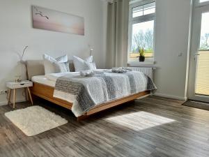 una camera da letto con un letto con una coperta e due finestre di Haus Concordia 2 Wellenreiter a Thiessow