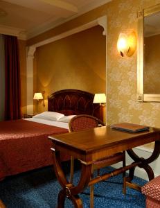 um quarto de hotel com uma cama, uma secretária e uma mesa em Art Hotel Orologio em Bolonha