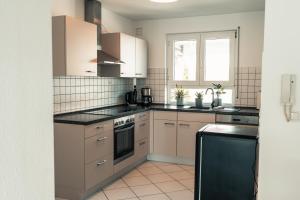 a kitchen with white cabinets and black counter tops at Ferienwohnung Frickenhausen am Main in Frickenhausen