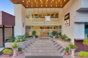 een lobby van een gebouw met trappen en potplanten bij Hotel Centre Point Jamshedpur in Jamshedpur