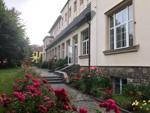 a building with pink flowers in front of it at Grandhotel Nový Bor in Nový Bor