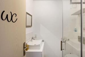 bagno bianco con lavandino e servizi igienici di Ein Bett im Kornfeld im Souterrain a Welver