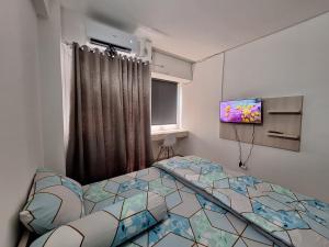 um quarto com uma cama e uma televisão de ecrã plano em Grand Sentraland Karawang by DnA Rooms em Karawang