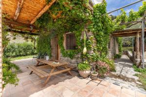 an outdoor patio with a wooden table and vines at La Terrera in Órgiva