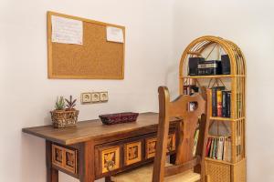 uma secretária de madeira com uma cadeira e uma estante de livros em La Terrera em Órgiva