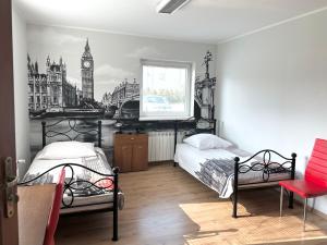 a bedroom with two beds and a picture of big ben at Leo Hostel in Poznań +38 photos