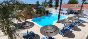 - une vue sur la piscine bordée de parasols dans l'établissement Casa Almeida, à Vimieiro