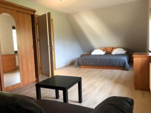 a bedroom with a bed and a table in a room at Sodyba Galsto Skardis in Neravai