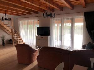 a living room with a couch and a television at Sodyba Galsto Skardis in Neravai