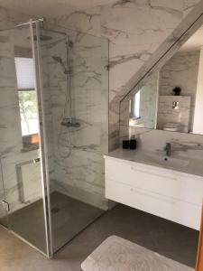 a bathroom with a shower and a sink at Sodyba Galsto Skardis in Neravai +28 photos