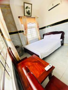a bedroom with a bed and a chair and a desk at Hoa Bien Motel in Ly Son