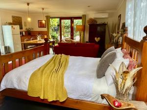 a bedroom with a bed with a yellow blanket on it at The Red Barn right in the heart of historic Berry in Berry