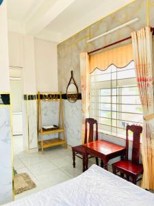 een slaapkamer met een bed en 2 stoelen en een tafel bij Hoa Bien Motel in Ly Son