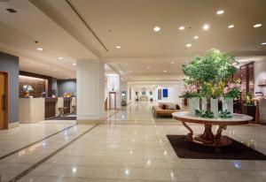 a lobby with a table with flowers on it at Hotel Associa Toyohashi in Toyohashi