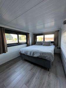 ein Schlafzimmer in einem Wohnwagen mit einem Bett und zwei Fenstern in der Unterkunft Gaia Tiny Houses Butik Hotel in Bodrum City