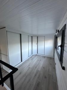 een lege kamer met witte muren en houten vloeren bij Gaia Tiny Houses Butik Hotel in Bodrum City