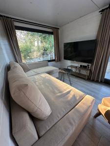 a large couch in a living room with a large window at Gaia Tiny Houses Butik Hotel in Bodrum City
