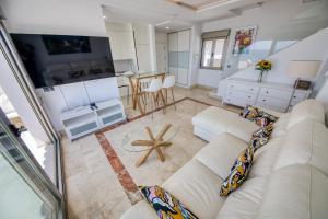 een woonkamer met een witte bank en een tafel bij Penthouse Carabela Seaviews in Benalmádena