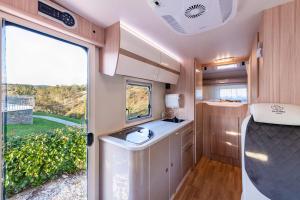an rv bathroom with a sink and a window at Autorulote Camperent in Ştefăneştii de Jos +18 photos