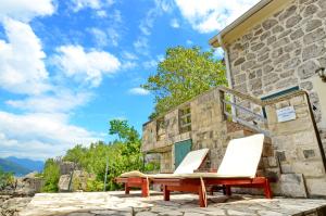 2 ligstoelen en een tafel op een patio bij Holiday Home Brinic in Tivat